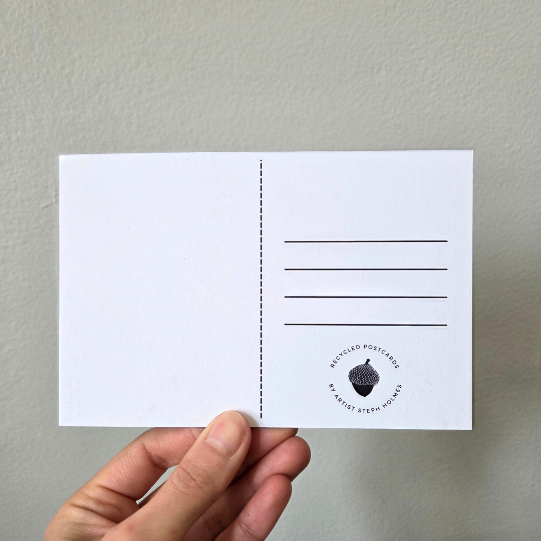 A hand holding an art print postcard.