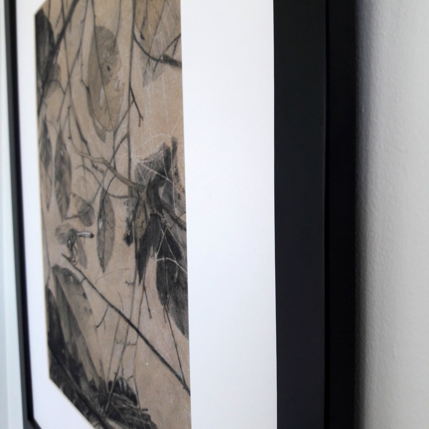 A close up of a black frame on a white wall.