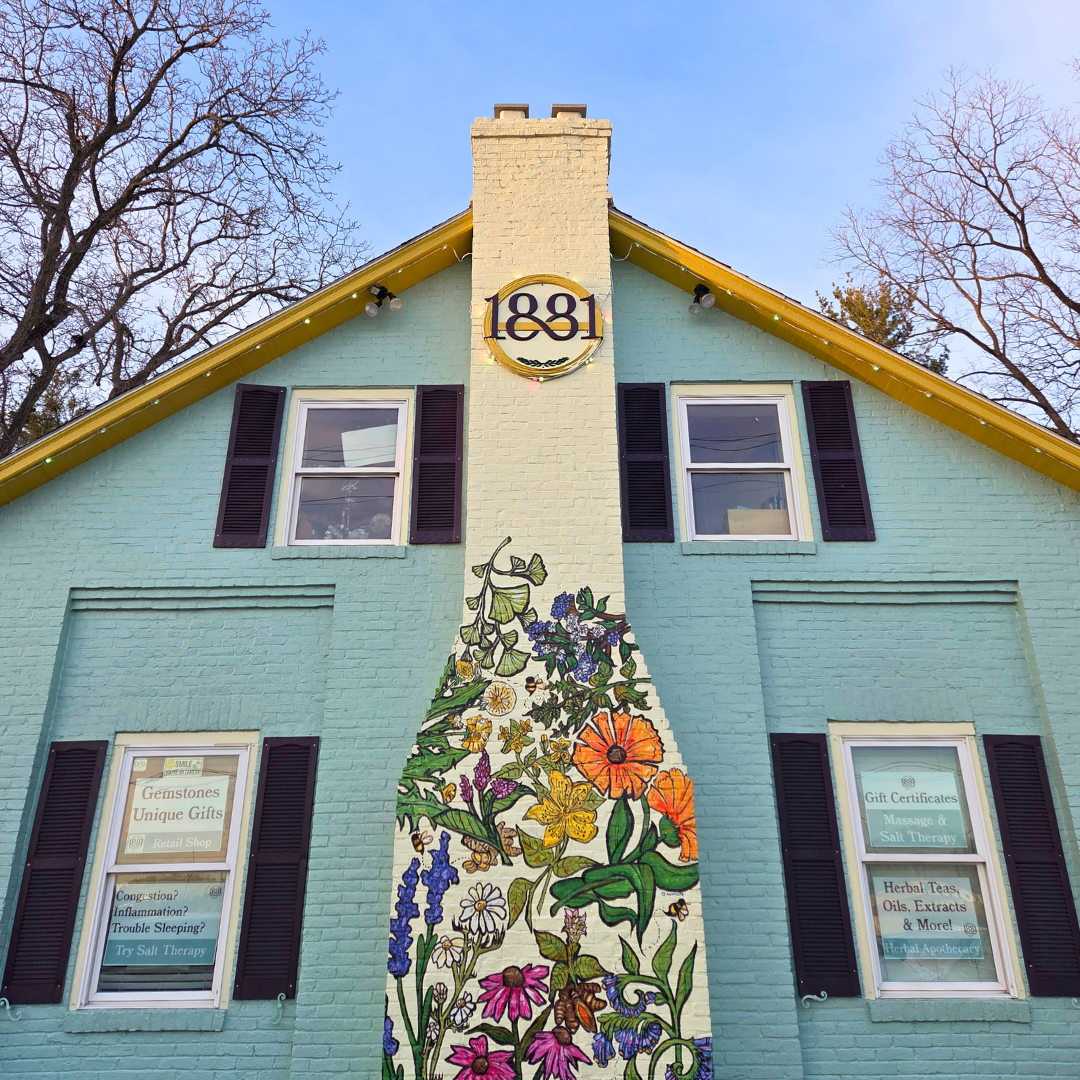 Building with a decorative mural of flowers and the year 1881 on a blue facade.