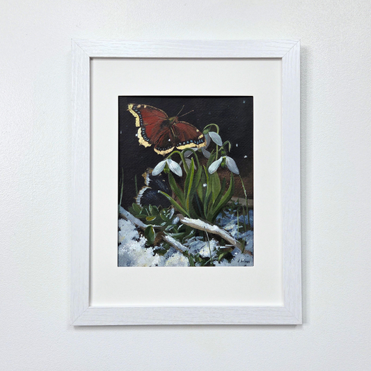 Framed artwork of a butterfly on snowdrops against a white wall