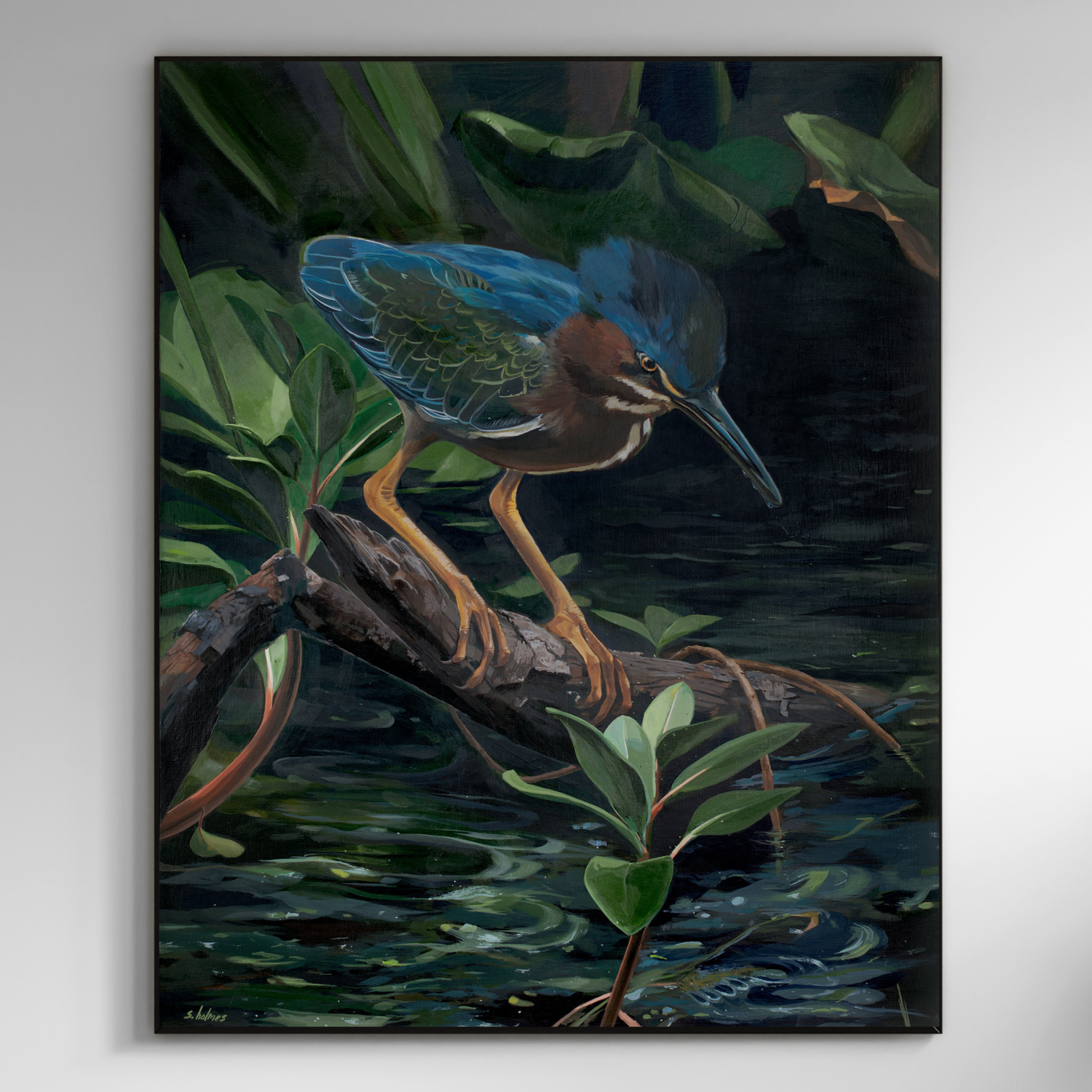 A framed painting of a green heron standing on a log in dark water with green foliage, shown hanging on a light gray wall.