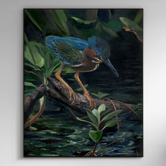 A framed painting of a green heron standing on a log in dark water with green foliage, shown hanging on a light gray wall.