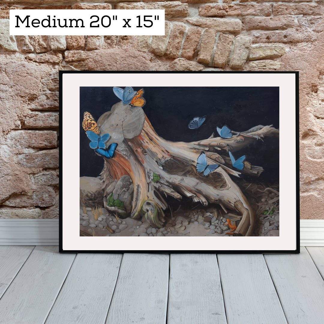 An art print framed and leaning against a brick wall.