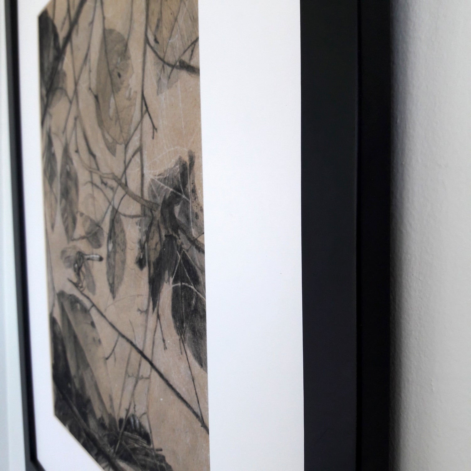 A close up of a black frame on a white wall.